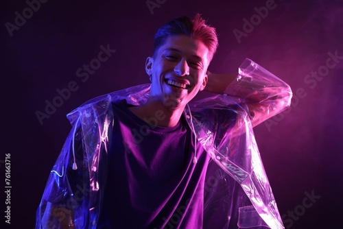 Young man wearing clear coat in neon lights with smoke effect