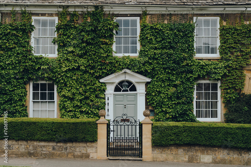 Facade of a traditional house in Broadway, Cotswolds, UK, covered with ivy. photo