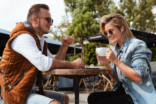 Joyful couple engaged in conversation over coffee at an outdoor cafe