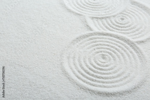 Zen rock garden. Circle patterns on white sand, closeup. Space for text