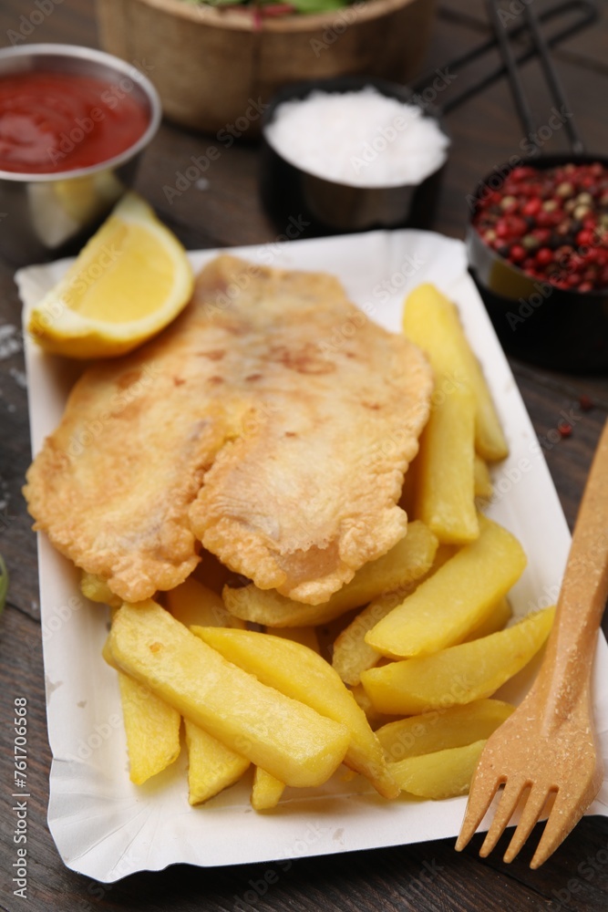 Delicious fish and chips served on wooden table, closeup