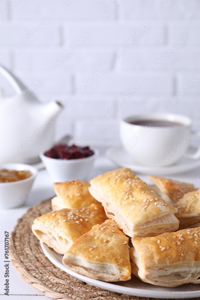 Delicious puff pastry on white table against brick wall Delicious puff pastry on white table against brick wall
