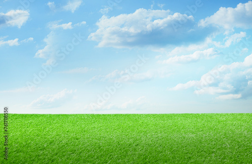 Green grass under blue sky with clouds