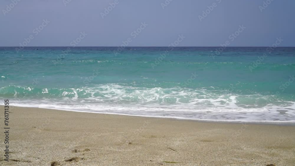 Foamy turquoise sea waves crashing onto the beach sand. Foamy turquoise sea waves crashing onto the beach sand.