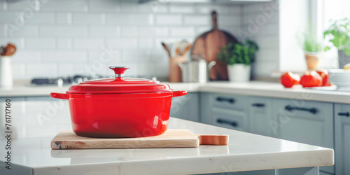 Bright Kitchen Space with Red Cookware. A vibrant red pot stands out on the wooden countertop of a sunny, well-appointed kitchen with modern appliances.