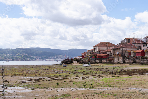 View of the town of Combarro in Galicia from the shore of the estuary. Landscape with cloudy sky and the village on the estuary.