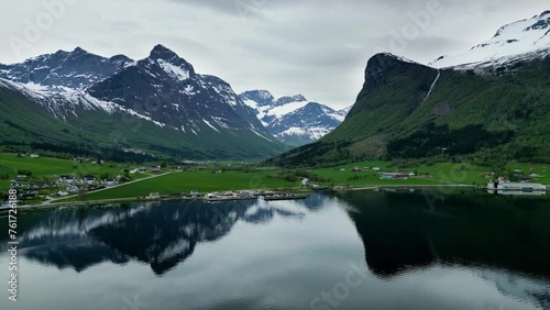 Snowy mountains reflecting in the water of the Norwegian fjord in Innfjorden, Rauma, Norway. photo