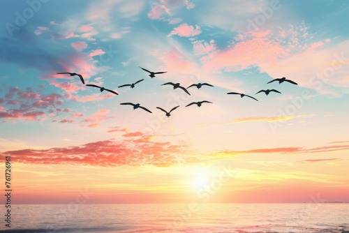 Flock of birds flying over a serene ocean at sunrise with colorful clouds in the sky. Concept of freedom  nature  and tranquility. 