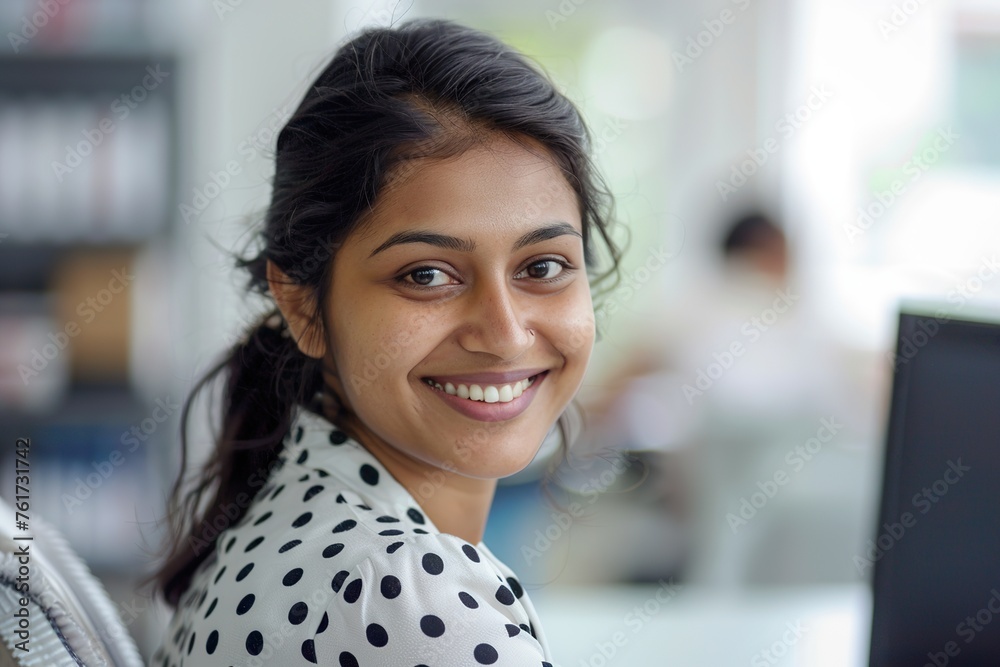 Portrait of a smiling Indian woman in a polka dot shirt at the office Portrait of a smiling Indian woman in a polka dot shirt at the office