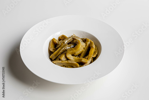 Marinated pickled cactus. Mexican cuisine. Pickled opuntia  isolated, on white plate, white background.