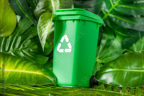 Green waste bin with recycling symbol standing among the natural lush greenery of the rainforest, Environmental concept, sustainable development, green deal, nature friendly, biodegradable products