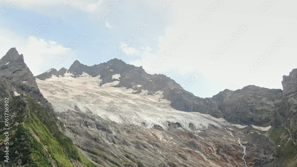 Amazing panorama of the glacier with snow between the mountain ranges . Blue sky. Amazing panorama of the glacier with snow between the mountain ranges . Blue sky.