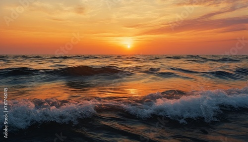  a sunset over a body of water with waves in the foreground and a bright orange sky in the background.