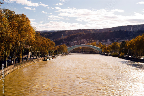 Panoramic view of the Kura River and the pedestrian bridge of Peace in Tbilisi on an autumn sunny day