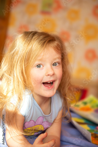 cute girl with blond red hair with emotions of joy and pranks on her face . Face close-up. home education. Sincere childhood emotions are genuine.