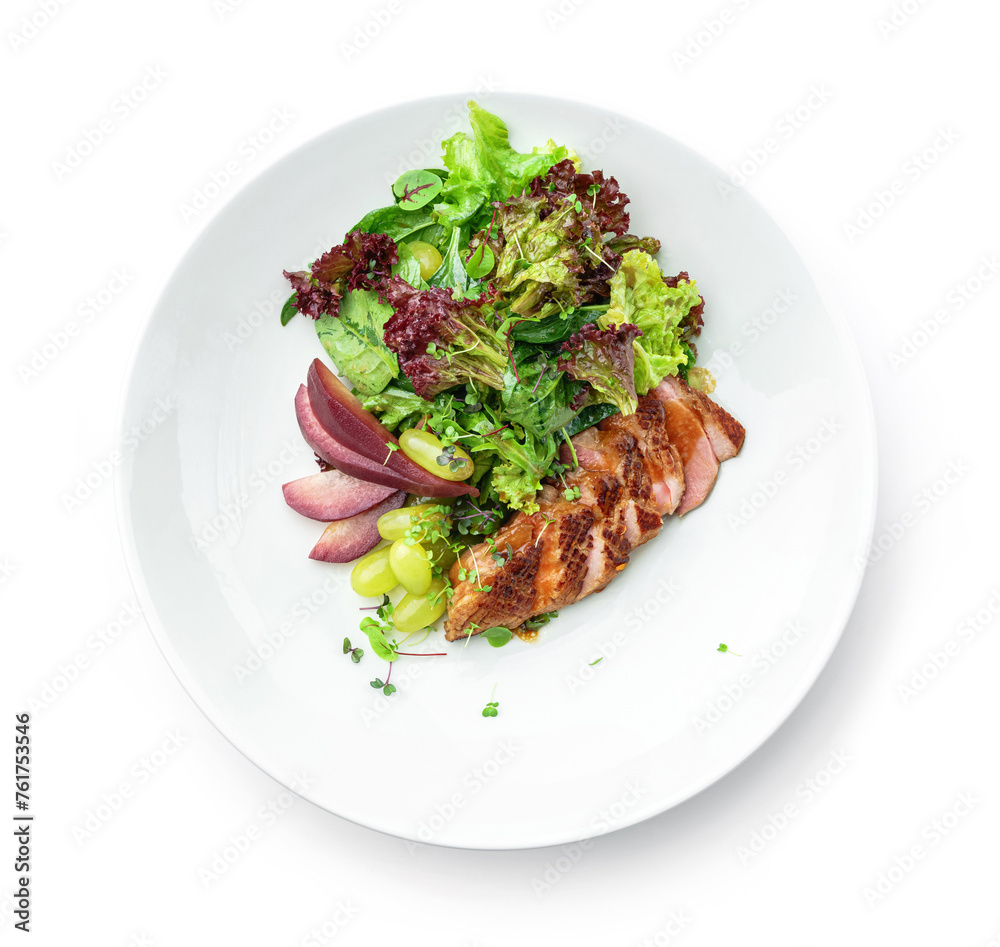 Healthy salad with medium rare beef steak, pear, grapes, lettuce, arugula, and sauce in plate isolated on white background. Healthy food, top view