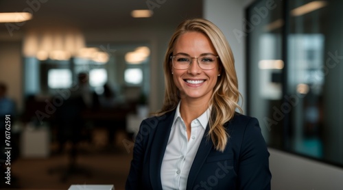 Businesswoman in glasses standing with a smiling face in office 