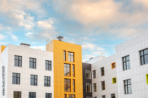 Canvastavla Part of building with metal facades of different colors and windows of different shapes against the sky