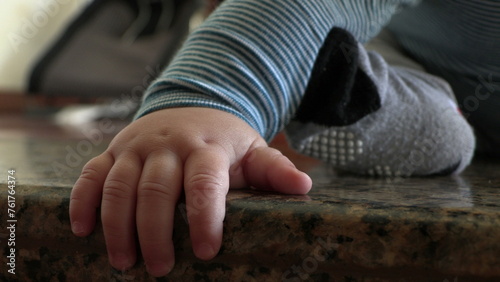Cute baby boy hands closeup on floor discovering the world