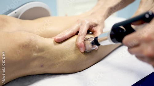 An adult man undergoes super inductive system therapy for recovery from trauma and rheumatic pathologies in a physiotherapy clinic.The handle is on the leg. Super Inductive System, SIS. photo