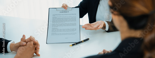 Business executive signing contract agreement document on the bale with the help from company attorney or lawyer service in law firm office. Business investing and finalizing legal processing. Shrewd photo