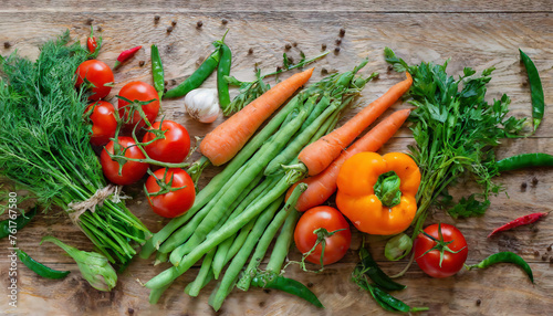 A diverse selection of fresh vegetables, including tomatoes, dill, bell peppers, carrots, and green beans on vintage wooden table