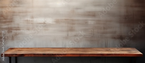 A brown rectangular hardwood table with a wood stain finish sits on the plywood flooring in front of a brick wall, showcasing a beautiful varnish pattern