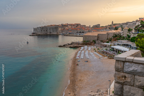 Sunset landscape with Banje beach and old town of Dubrovnik, Dalmatia, Croatia. Medieval fortress on the sea coast. Popular travel destination. Summer vacation background