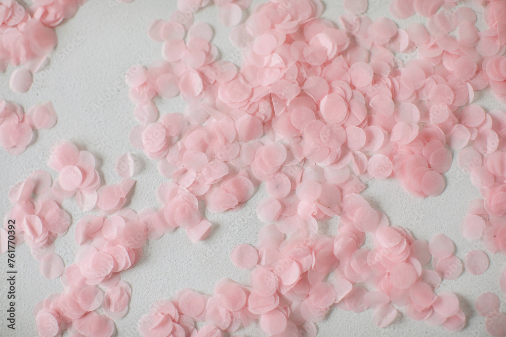 Pink confetti on a white background. Festive backdrop. 