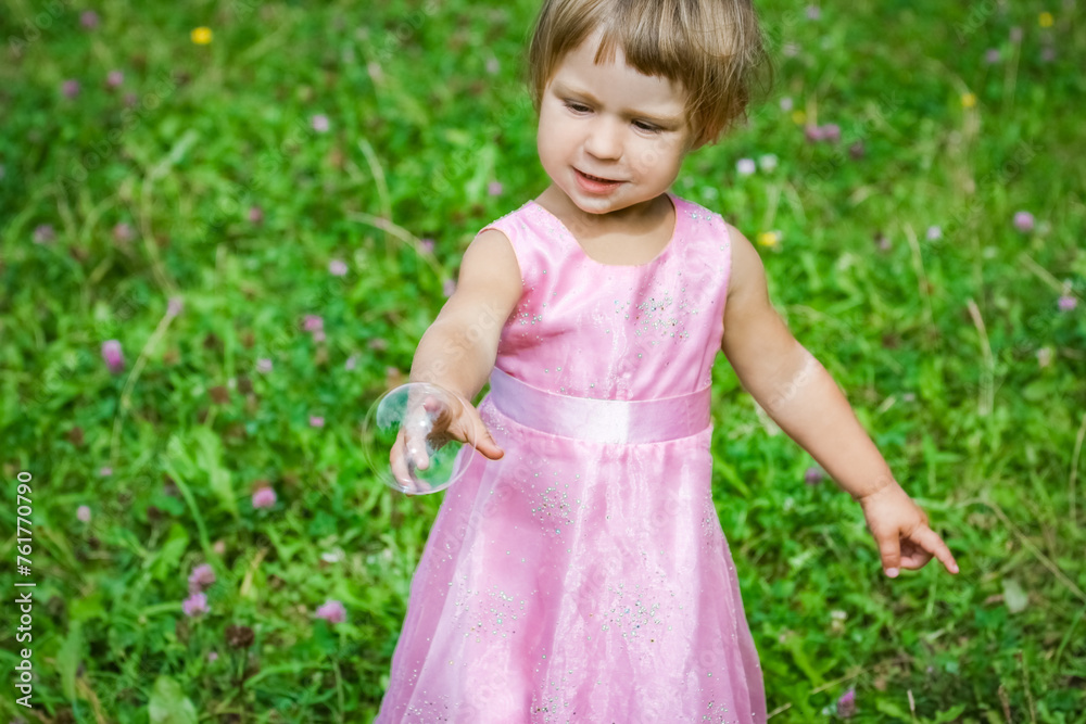 happy little girl chasing bubbles on nature in the park happy little girl chasing bubbles on nature in the park