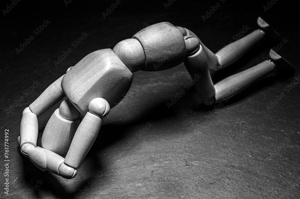Holzpuppe kniet auf dem Boden und symbolisiert Verzweiflung und Trauer Holzpuppe kniet auf dem Boden und symbolisiert Verzweiflung und Trauer