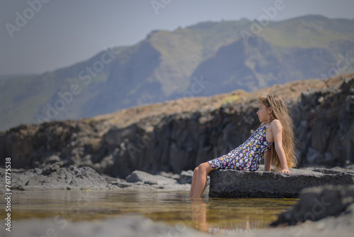 Little girl enjoying summer on the beach in natural pools