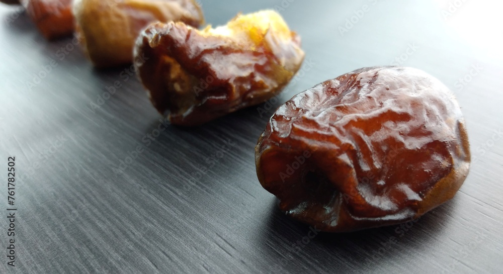Dried dates on a black background, close-up, selective focus Dried dates on a black background, close-up, selective focus