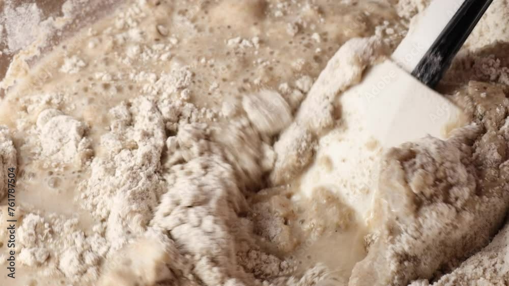 Kneading bread dough. a close-up of rye flour mixed with yeast and water using a silicone spatula. Kneading bread dough. a close-up of rye flour mixed with yeast and water using a silicone spatula.
