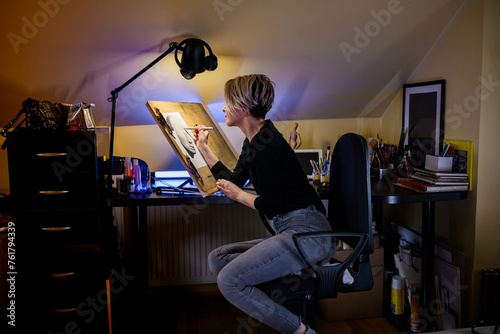 Εκτύπωση καμβά A talented portraitist is pencil drawing a portrait at her home studio