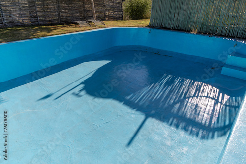 Portion of a fibreglass lined empty resort swimming pool. Concept for fixing cracks in old pools with a fibreglass lining.  