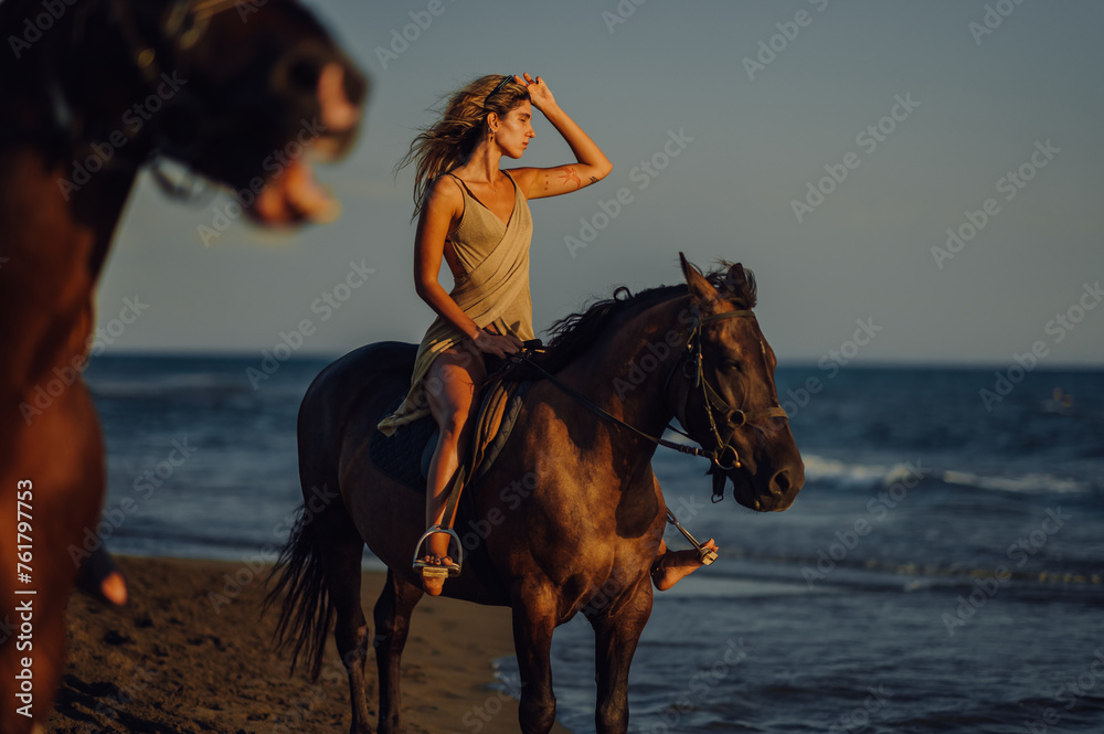 Portrait of a young woman riding a horse at summertime.