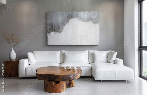Uma linda sala com sofá branco, mesa em madeira ao fundo uma parede cinza com um quadro moderno photo