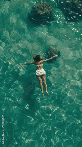 Young woman floating on back in the sea © Coosh448
