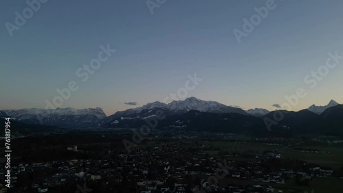 Scenic drone timelapse of sunset over the snowcapped Untersberg Mountain in Salzburg, Austria, while the Shot via drone in 4k.  photo