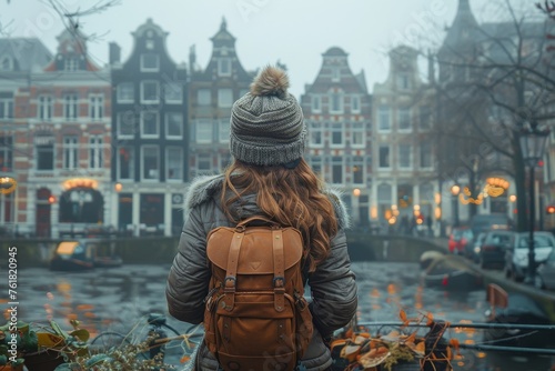 A female tourist gazes at the iconic canal houses of Amsterdam, reflecting the city's historic charm and travel
