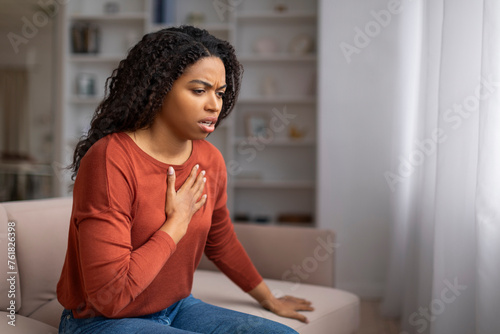 Ταπετσαρία Concerned young black woman suffering pain in chest while sitting on couch