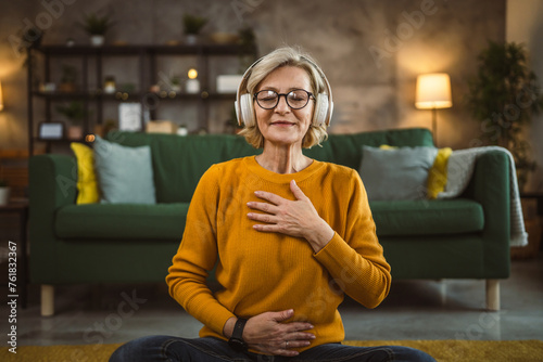 Mature blonde woman practice guided meditation manifestation at home photo