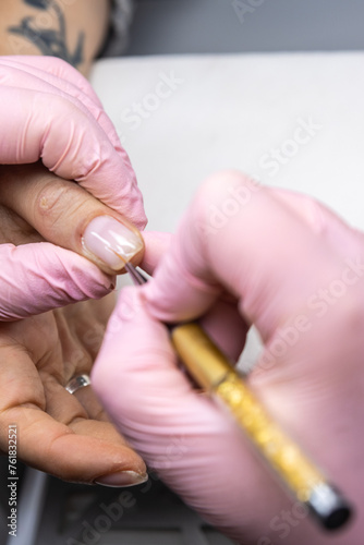 Close-up of manicurist painting nails with precision