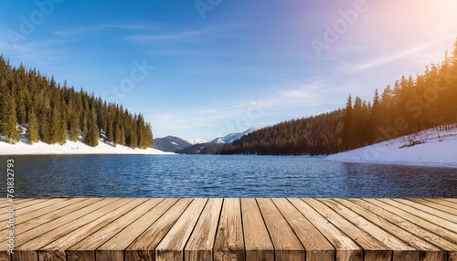 empty wooden table top background with free copy space snowy winter mountain lake nature with spruce tree forest at sunset light panorama with copy space © Nichole