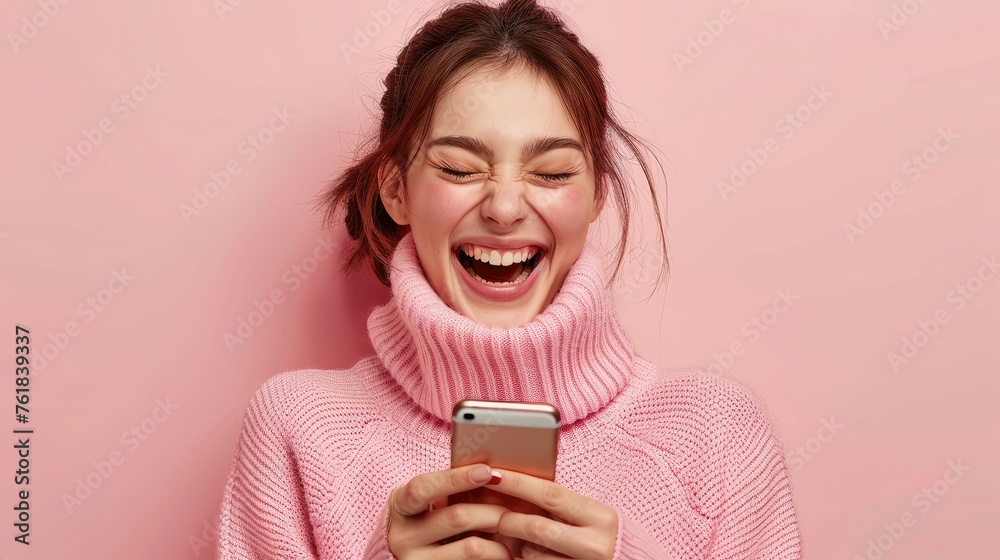 Joyful young woman with pink sweater laughing using phone. Joyful young woman with pink sweater laughing using phone.