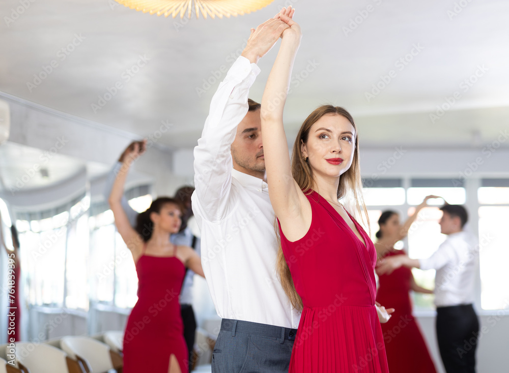 Adult man and young woman dance ballroom dance waltz in studio