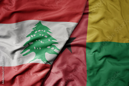 big waving national colorful flag of guinea bissau and national flag of lebanon. photo