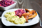baked chicken leg, mashed potatoes and red cabbage salad