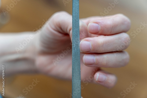 Woman s hands doing manicure treatment  filing nails with a nail file